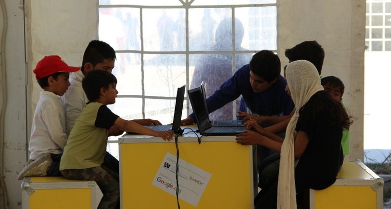 Photo d'enfants utilisant les ordinateurs de l'Ideas Box dans le camp de réfugiés d'Eleonas à Athènes
